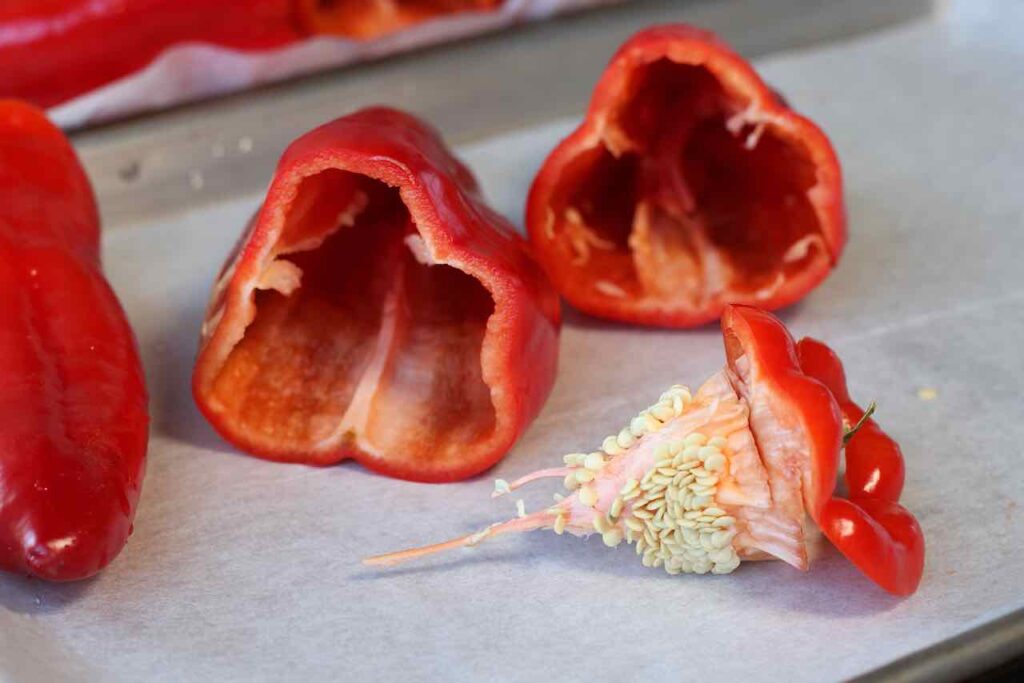 cutting tops off peppers for roasting